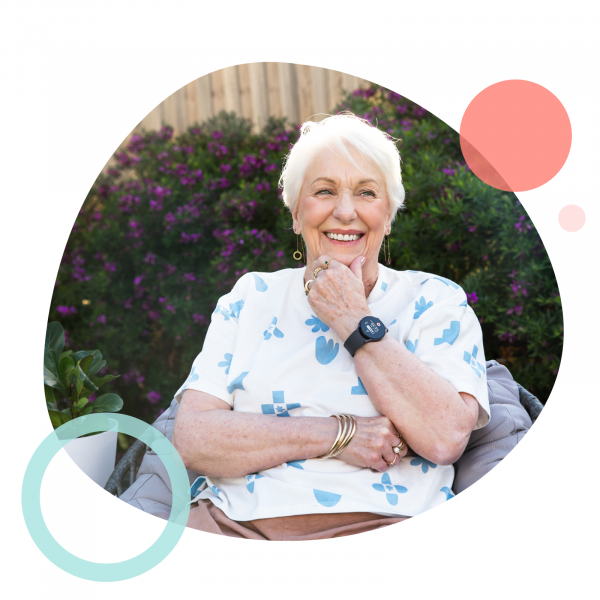 An older woman in Australia wearing the MePACS Solo Connect personal alarm watch in her garden.